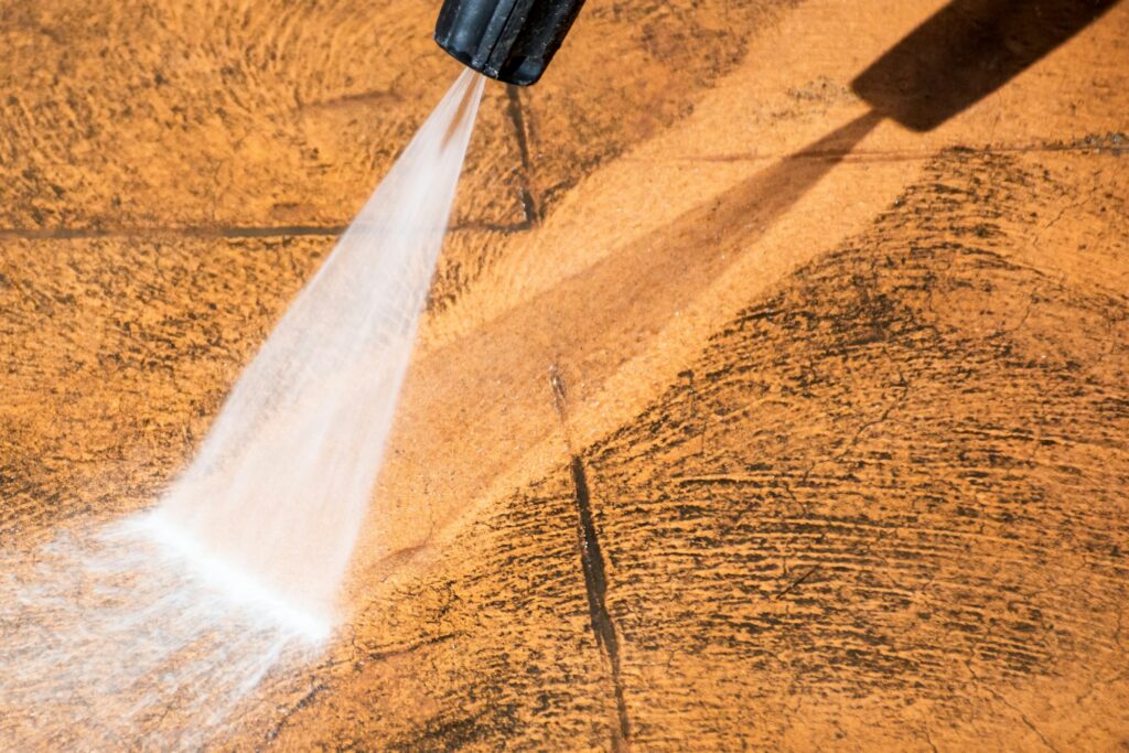 Cleaning backyard paving tiles with pressure washer. Spring clean up